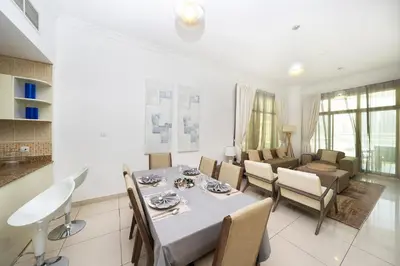 a dining room and living room with a table and chairs at 2 Bed in Atlantic Tower 2 by PK Holidays in Dubai