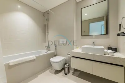 a bathroom with a sink toilet and a mirror at Dubai Harbour & Sea Views 1 BR Near Key Landmarks, Marina Vista T1, Emaar Beachfront by Deluxe Holiday Homes in Dubai
