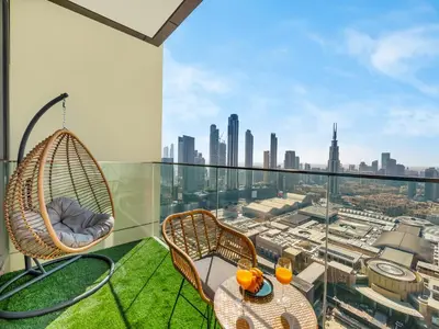 a balcony with a table and chairs and a view of the city at Brand New! Downtown views located on Dubai Mall in Dubai