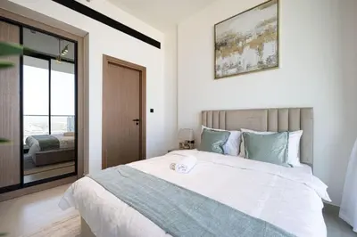 a bedroom with a large white bed and a window at Large New Apartment Pool in JVC Community in Dubai