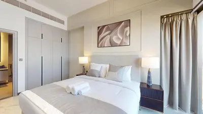a bedroom with a large white bed with two lamps at Mag Eye 890 - Airy One Bedroom in Meydan in Dubai