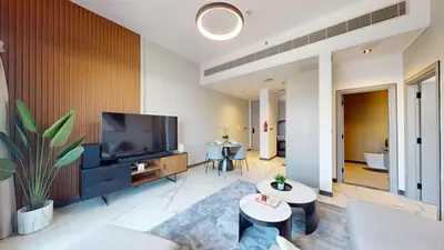 a living room with a flat screen tv and a couch at Mag Eye 890 - Airy One Bedroom in Meydan in Dubai