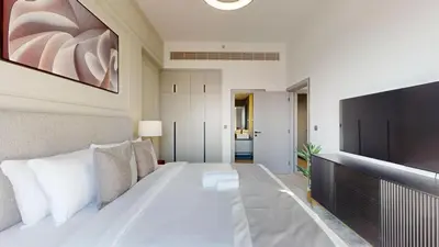 a bedroom with a large white bed and a flat screen tv at Mag Eye 910 - Magnificent One Bedroom in Meydan in Dubai