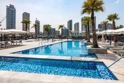 a swimming pool with palm trees and buildings at Vacationer I Luxury 2BR I Marina Views I Close to JBR Beach I Sparkle Tower in Dubai