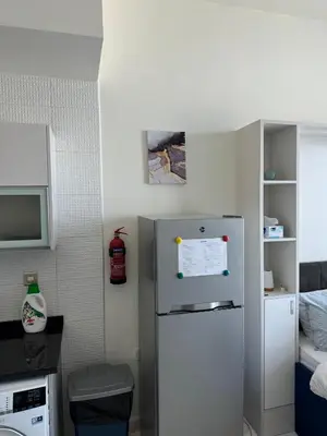 a small kitchen with a refrigerator in a room at Bayz Business Bay Lux Studio with Resort Amenities in Dubai