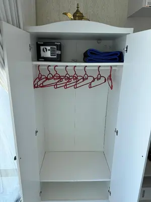 a white cabinet with red handles in a room at Bayz Business Bay Lux Studio with Resort Amenities in Dubai
