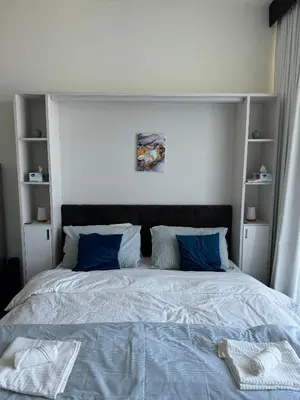 a bedroom with a large bed with blue pillows at Bayz Business Bay Lux Studio with Resort Amenities in Dubai