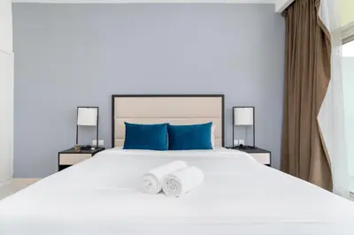 a bedroom with a large white bed with blue pillows at Ahlan HH - Luxury 2BR Damac Tower 108 at High Floor in Dubai