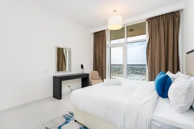 a white bedroom with a large bed and a window at Ahlan HH - Luxury 2BR Damac Tower 108 at High Floor in Dubai