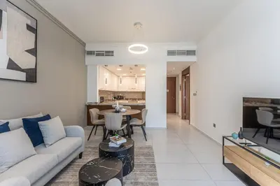 a living room with a couch and a table at HAVN - New 1 Bedroom Apartment in Regent Court JVC in Dubai