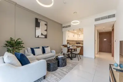a living room with two couches and a table at HAVN - New 1 Bedroom Apartment in Regent Court JVC in Dubai