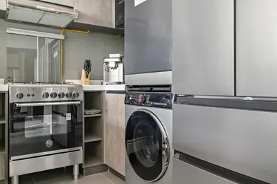 a kitchen with a washing machine and a stove at Stonetree - Cozy 1 BR at MBL Near Metro in Dubai