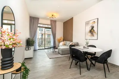 a living room with a table and chairs at Sleek & Modern 1BR with Luxury Pool in JVC in Dubai