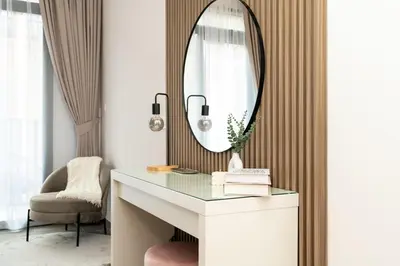 a dressing table with a mirror and a chair at Sleek & Modern 1BR with Luxury Pool in JVC in Dubai