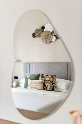 a mirror reflecting a bed with pillows on it at GuestReady - Beautiful home in the JLT area in Dubai