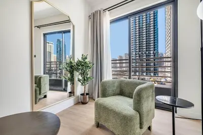 a living room with a chair and a large window at GuestReady - Beautiful home in the JLT area in Dubai