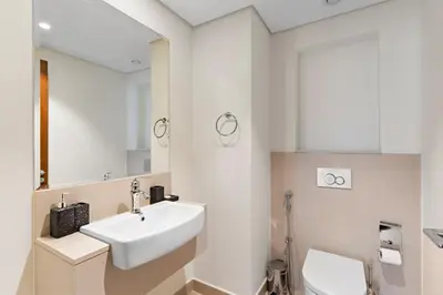 a white bathroom with a sink and a toilet at Stonetree - Spacious 2BR at Dubai Creek Residences in Dubai