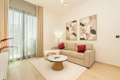 a living room with a couch and a table at Luxury 1BR Apartment in JVC with Stunning Pool in Dubai