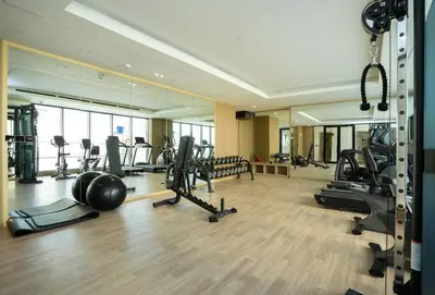 a gym with treadmills and exercise equipment in a building at Luxury 1BR Apartment in JVC with Stunning Pool in Dubai