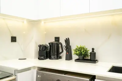 a kitchen counter with appliances on a white counter top at Luxury 1BR Apartment in JVC with Stunning Pool in Dubai