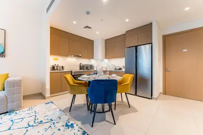 a kitchen and dining room with a table and chairs at Community View 2BR with Balcony, Surf at Creek Beach Building 2, Creek Harbour by Deluxe Holiday Homes in Dubai