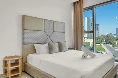 a bedroom with a large white bed with a large window at Bellavista - 2 Bedroom Downtown Views II T2 in Dubai
