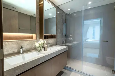 a bathroom with two sinks and a glass shower at 2BD designed by Elie Saab with Private Beach Sea View by EE Holiday Homes in Dubai