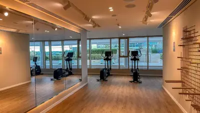 a gym with treadmills and ellipticals in a room with windows at 2BD designed by Elie Saab with Private Beach Sea View by EE Holiday Homes in Dubai