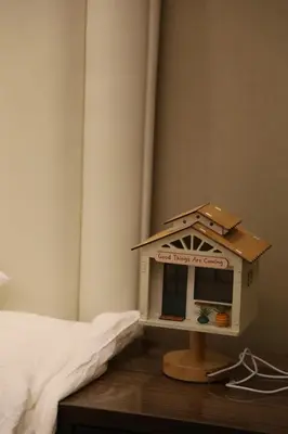 a toy bird house sitting on a table next to a bed at \u6e29\u99a8\u53ef\u7231\u7684\u6574\u5957\u516c\u5bd3 in Dubai