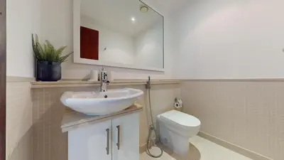 a bathroom with a sink and a toilet and a mirror at Paloma - Three Bed with Mesmerizing Marina View in Dubai
