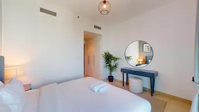 a bedroom with a white bed and a mirror at Paloma - Three Bed with Mesmerizing Marina View in Dubai