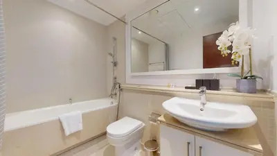 a bathroom with a sink and a toilet and a mirror at Paloma - Three Bed with Mesmerizing Marina View in Dubai