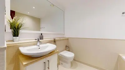 a bathroom with a sink and a toilet and a mirror at Paloma - Three Bed with Mesmerizing Marina View in Dubai