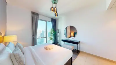 a bedroom with a white bed and a mirror at Paloma - Three Bed with Mesmerizing Marina View in Dubai