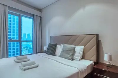 a bedroom with a large bed with a large window at Dubai Marina, Beach & Marina View , 2 Bed Perfect for Groups in Dubai