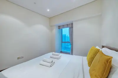 a white bedroom with a large white bed and a window at Dubai Marina, Beach & Marina View , 2 Bed Perfect for Groups in Dubai