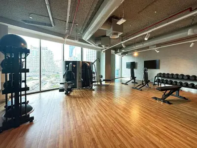 an empty gym with a hard wood floor and windows at Fresh New 2 Bedroom! Amazing Burj Khalifa View! 5-star Pool & Gym Access! in Dubai