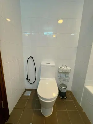 a white bathroom with a toilet and a shower at 5 minutes walk to Dubai mall and Burj Khalifa in Dubai