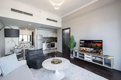 a living room with a couch and a tv at Panoramic Marina View - 1BR - Walk to the beach in Dubai