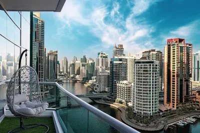 a chair on a balcony with a view of a city at Panoramic Marina View - 1BR - Walk to the beach in Dubai