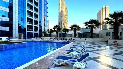 a swimming pool with lounge chairs in a city at Panoramic Marina View - 1BR - Walk to the beach in Dubai