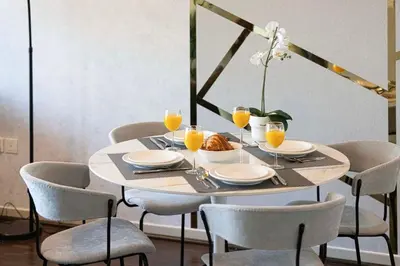 a dining room table with chairs and orange juice glasses at Panoramic Marina View - 1BR - Walk to the beach in Dubai