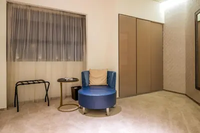 a waiting room with a blue chair and a table at Lavish Studio at Creek Heights Residences - Boutique Concept by UDH in Dubai
