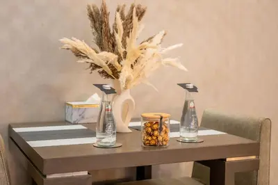 a table with two bottles and a vase on it at Lavish Studio at Creek Heights Residences - Boutique Concept by UDH in Dubai