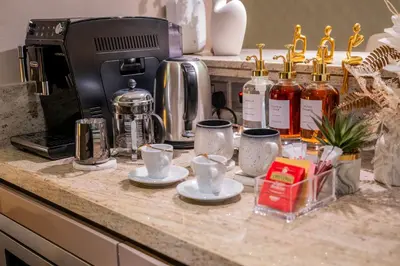 a counter top with cups and coffee cups on it at Lavish Studio at Creek Heights Residences - Boutique Concept by UDH in Dubai