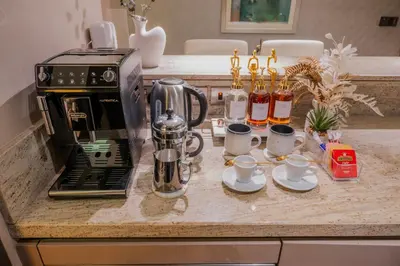 a kitchen counter with a coffee maker and coffee cups at Lavish Studio at Creek Heights Residences - Boutique Concept by UDH in Dubai