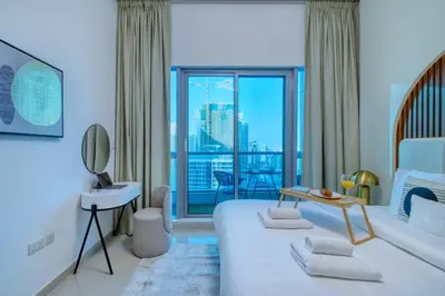 a bedroom with a bed and a view of a city at Waterfront 1BR - Marina Views - Walk to Beach & Mall in Dubai