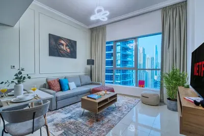 a living room with a couch and a large window at Waterfront 1BR - Marina Views - Walk to Beach & Mall in Dubai