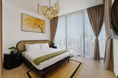 a bedroom with a bed and a large window at Daniels 1BR at Waves Grande In Sobha Hartland in Dubai