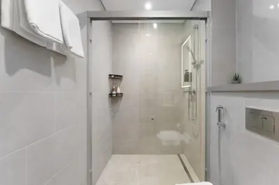 a shower with a glass door in a bathroom at Daniels 1BR at Waves Grande In Sobha Hartland in Dubai